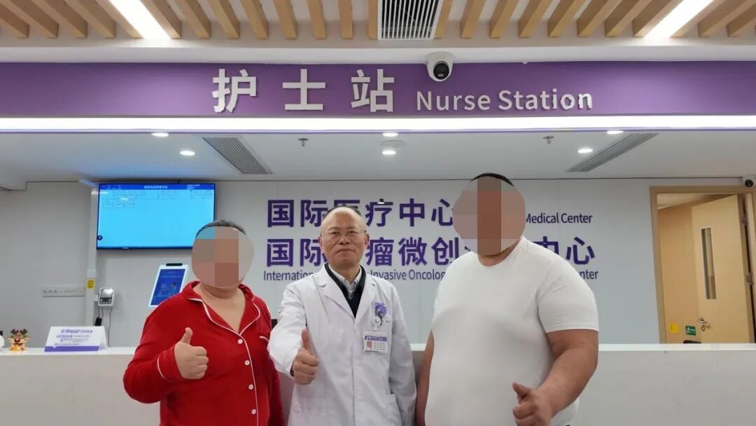 Two patients with obscured faces standing with a doctor at an international medical centre nurse station