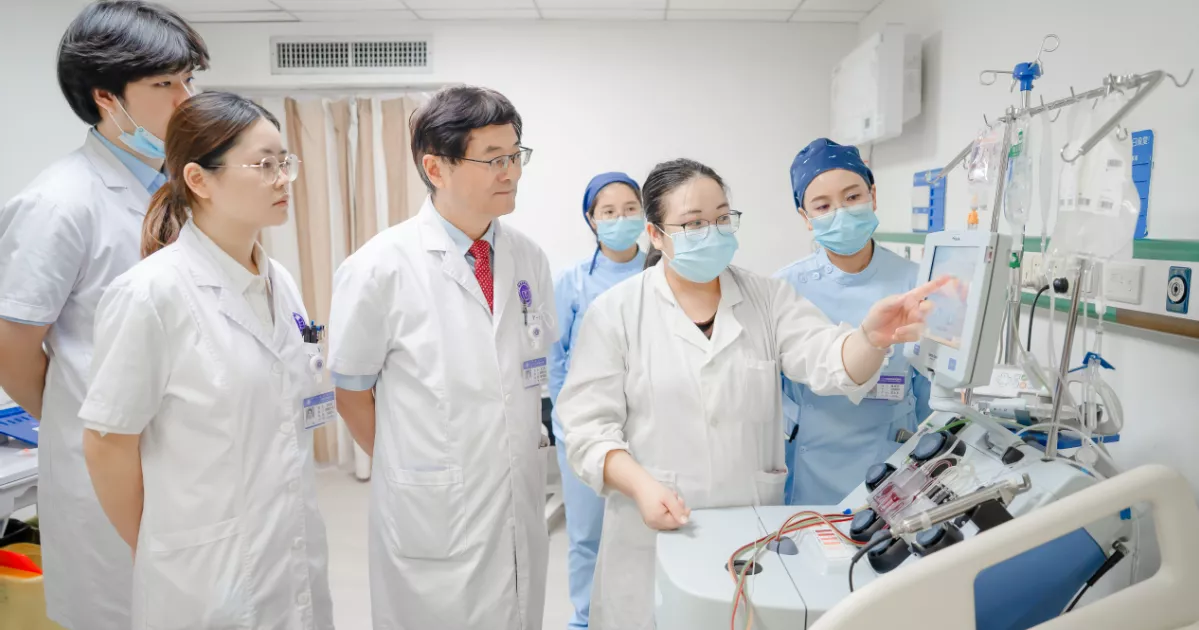 Clinical team reviewing cell-collection equipment in a hospital treatment room